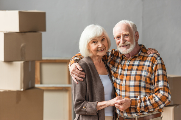 ηλικιωμένο ζευγάρι αγκαλιάζει και κρατά τα χέρια στο νέο σπίτι, κινούμενη έννοια - Φωτογραφία, εικόνα