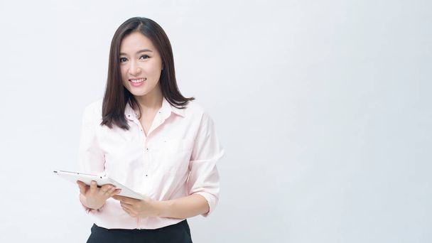 portrait of confident businesswoman wearing  pink shirt is holding tablet isolated over white background studio - 写真・画像
