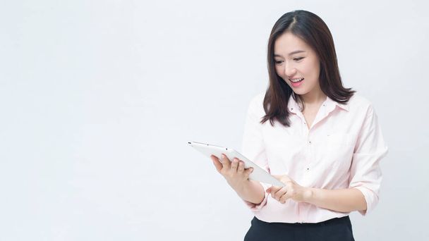 portrait of confident businesswoman wearing  pink shirt is holding tablet isolated over white background studio - Foto, immagini