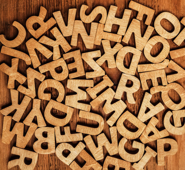 Wooden alphabet letters isolated on wooden background. A lot many wooden letters.  - Photo, Image