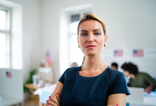 Portrait of confident woman voter in polling place, usa elections concept. - 写真・画像