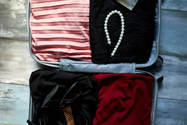 Mala de embalagem em casa com itens da mulher, acessórios na mala para viagens, viagem, férias. Espaço de cópia. - Foto, Imagem