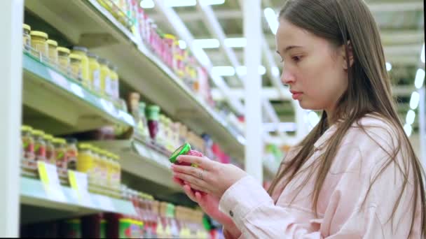 Ragazza che compra cibo barattolo di vetro al supermercato - Filmati, video