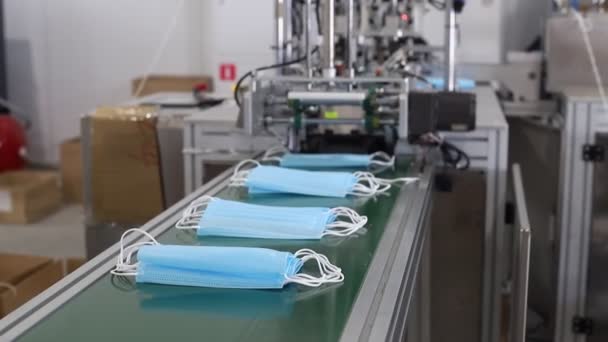 Industriële productie van medische maskers - zetten van de maskers in een stapel - maskers op de bocht - Video