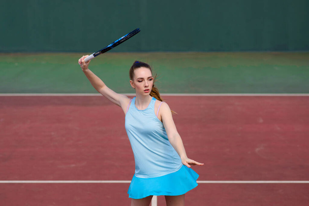 Sexy dívka tenista v bílých šatech a podpatky drží tenisovou raketu na hřišti. Mladá žena hraje tenis, sport - Fotografie, Obrázek
