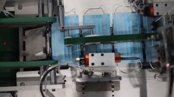 Production industrielle de masques médicaux - la machine assemble le masque - Séquence, vidéo
