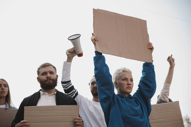Ryhmä aktivisteja, jotka antavat iskulauseita mielenosoituksessa. Miehet ja naiset marssivat yhdessä protestina kaupungissa.. - Valokuva, kuva