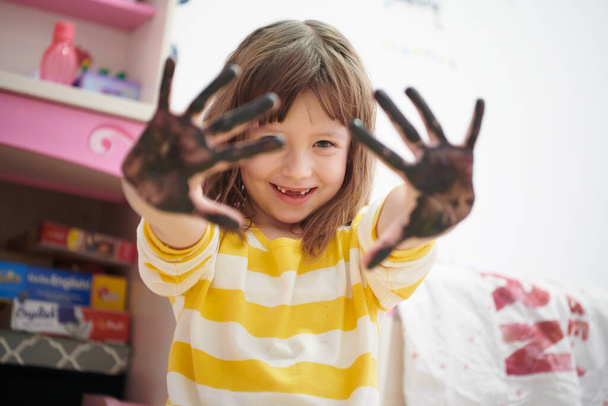 cute little girl at home painting with hands - 写真・画像