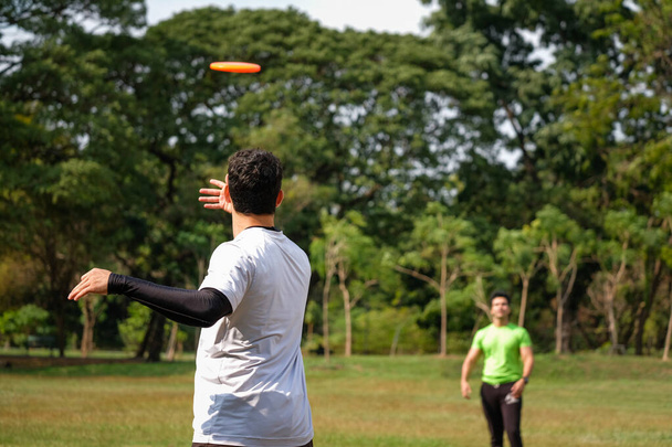 Giovane che gioca a frisbee nel parco - Foto, immagini