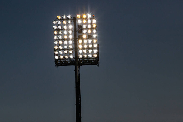 Stadyum ışıkları yansıtıcı ve koyu mavi gökyüzü - Fotoğraf, Görsel