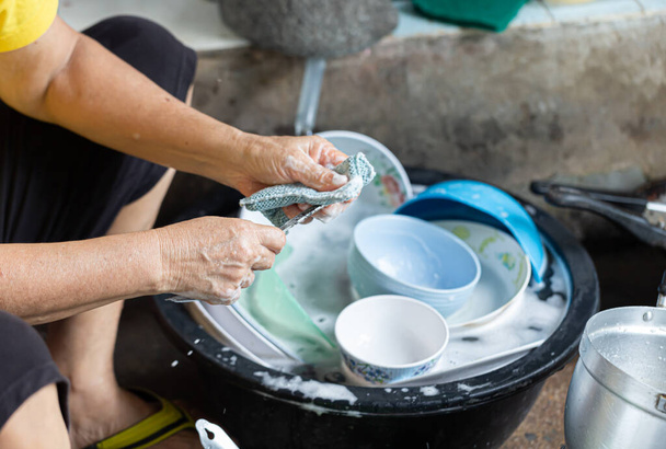Žena v domácnosti myje nádobí čisticím prostředkem.. - Fotografie, Obrázek