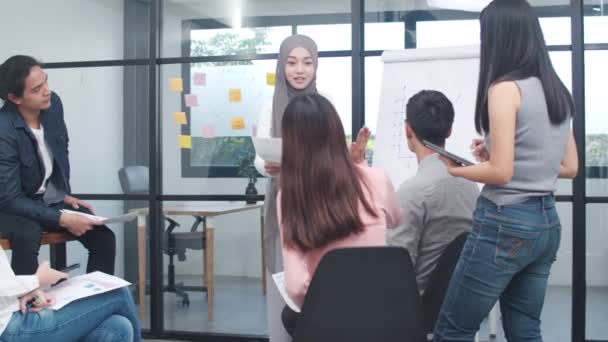 Asia businessmen and businesswomen meeting brainstorming ideas conducting business presentation project colleagues working together plan success strategy enjoy teamwork in small modern office. - Footage, Video