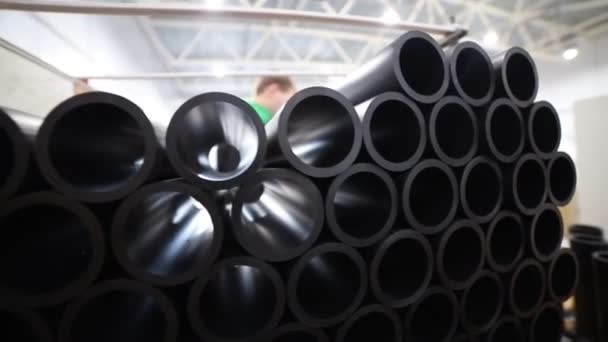 La lumière passe à travers les tubes en plastique noir dans l'entrepôt de fabrication - Séquence, vidéo