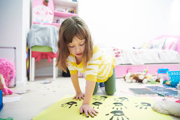 cute little girl at home painting with hands - 写真・画像