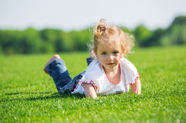 Маленькая счастливая девочка на траве
 - Фото, изображение