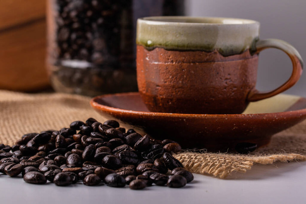Робуста кавові зерна і коричневі керамічні чашки кави
 - Фото, зображення