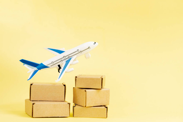 Airplane and stack of cardboard boxes. concept of air cargo and parcels, airmail. Fast delivery of goods and products. Cargo aircraft. Logistics, connection to hard-to-reach places. Banner, copy space. - Φωτογραφία, εικόνα