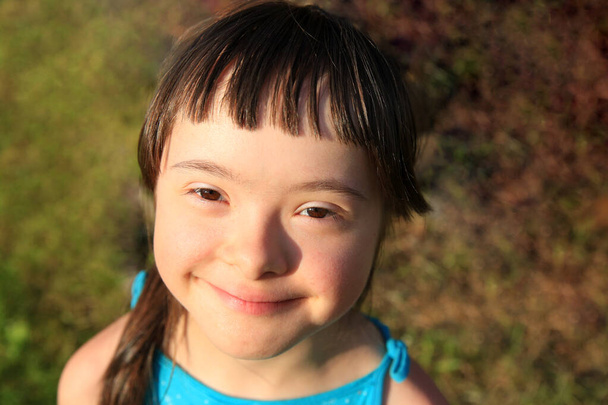 Portrét holčičky usmívající se na travnatém pozadí - Fotografie, Obrázek