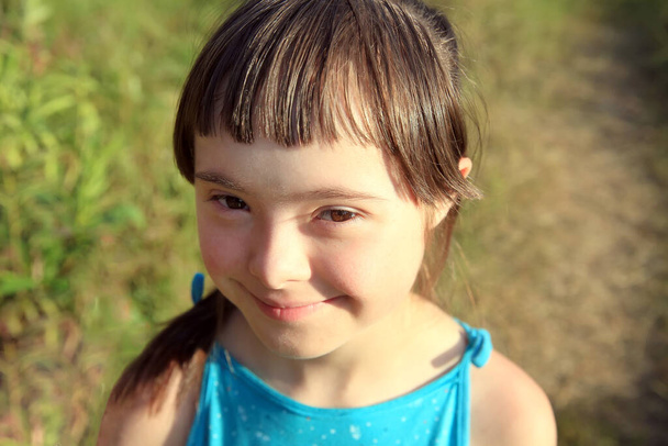 Портрет маленькой девочки, улыбающейся на фоне травы - Фото, изображение