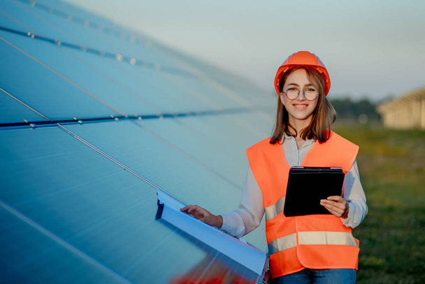 Inspecteur Engineer Vrouw Holding Digital Tablet Werken in zonnepanelen Power Farm, Photovoltaic Cell Park, Green Energy Concept. - Foto, afbeelding