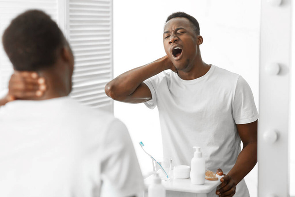 Sleepy African American Man Yawning Standing Near Mirror In Bathroom - Fotó, kép