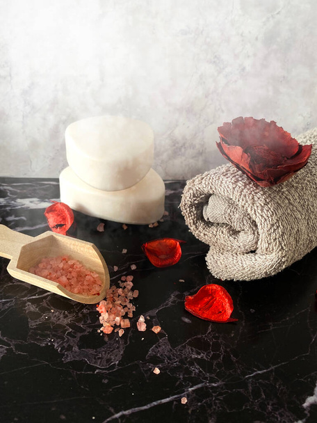 Pink bath salt and a rolled towel. Spa salon, relaxation and beauty products. - 写真・画像