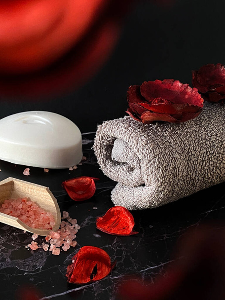 Pink bath salt and a rolled towel. Spa salon, relaxation and beauty products. - Foto, Imagen