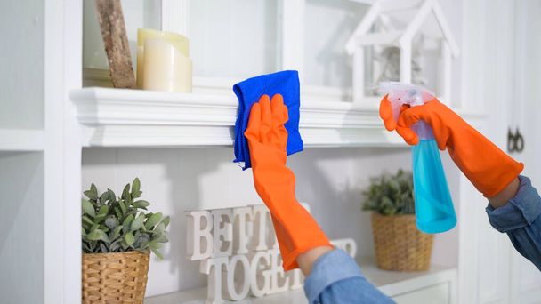 A woman with cleaning gloves using alcohol spray sanitiser to cleaning house, healthy and medical, covid-19 protection at home concept . - Foto, Imagem