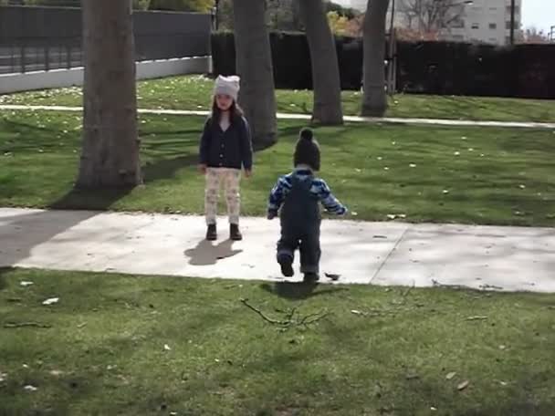 Schwester und Bruder spielen im Park. - Filmmaterial, Video