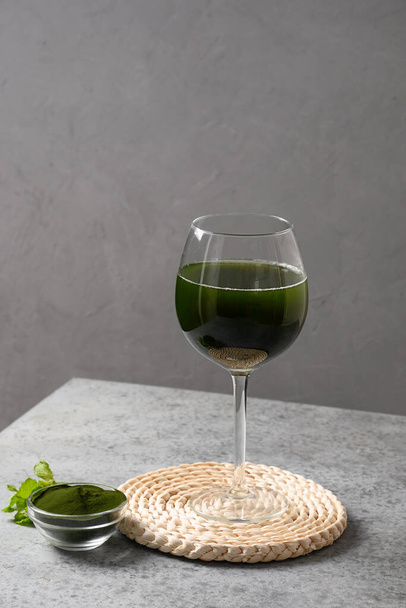 Chlorella healthy Detox beverage with lemon in glass on a grey background. Close up. - Foto, imagen