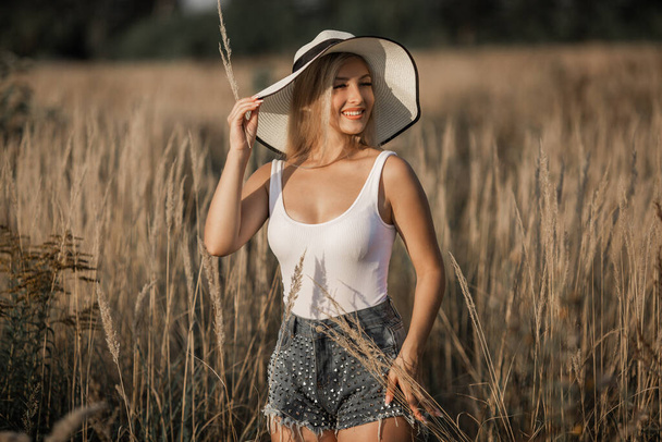 beautiful young woman in hat in summer field - Foto, Imagem