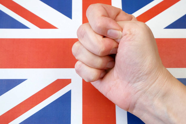 σφιγμένη γροθιά στο φόντο της σημαίας στη Βρετανία, διαμαρτυρίες στο ενωμένο βασίλειο  - Φωτογραφία, εικόνα