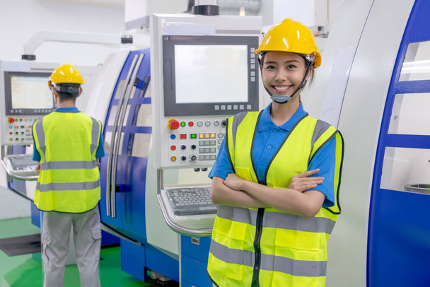 Εργοστάσιο εργαζόμενη γυναίκα με στολή σταθεί με σταυρό χέρι και χαμόγελο ματιά στην κάμερα. Έννοια της καλής διαχείρισης του συστήματος υποστήριξης βοηθήσει τους εργαζόμενους στη βιομηχανική εργασία των επιχειρήσεων με την ευτυχία στο χώρο εργασίας. - Φωτογραφία, εικόνα