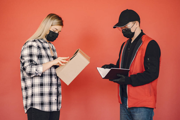 Delivery man in a medic mask with woman - Photo, Image