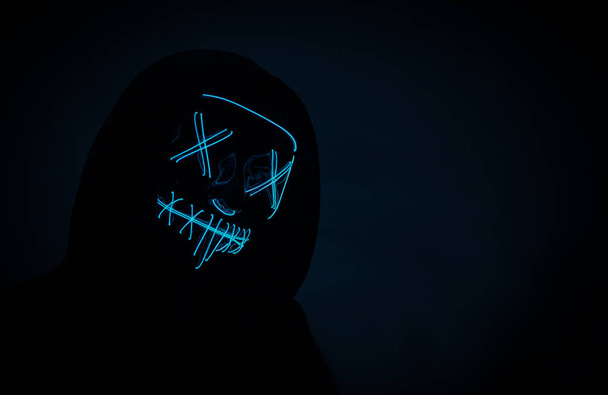 Ritratto di un hacker anonimo in maschera al neon, maschera di Halloween - Foto, immagini