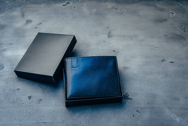 Black leather wallet on grey concrete background - 写真・画像