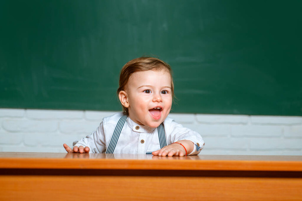 Preschool kids. Learning and education concept. Back to school. Funny preschooler on blackboard background. - Photo, Image