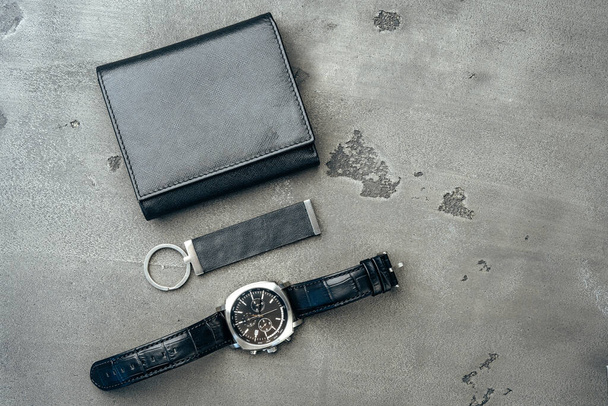 Male watch and leather wallet on dark grey surface - Valokuva, kuva