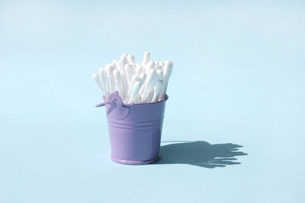 A lot of clean ear sticks in a miniature metal purple bucket. Cotton buds for cleaning ears. Body care. - Photo, Image