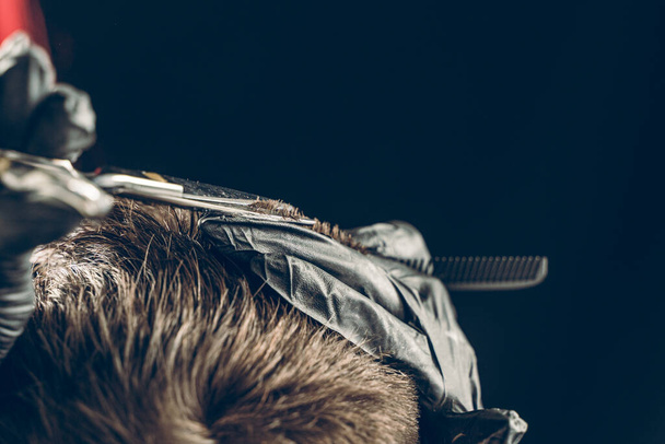 Cropped shot of barber cutting hair of customer with scissors - Photo, Image