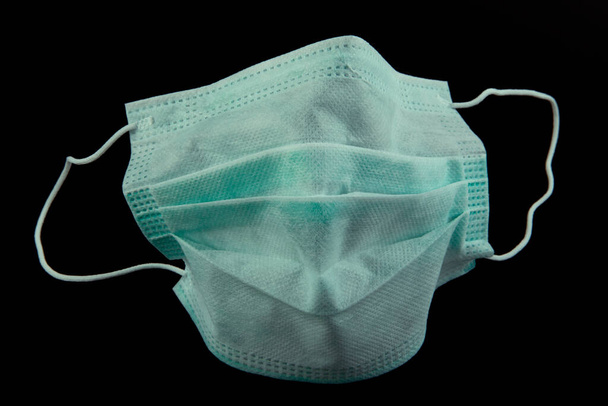 Coronavirus prevention face mask protection. Surgical mask with rubber ear straps. Typical 3-ply surgical mask to cover the mouth and nose. Procedure mask from bacteria. Protection concept. - Photo, Image