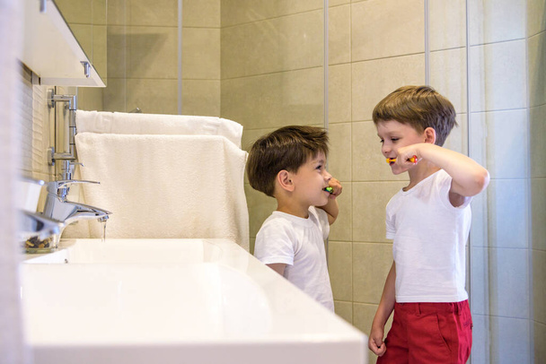 Deux frères se brossent les dents dans la salle de bain.Le début d'un nouveau jour. - Photo, image
