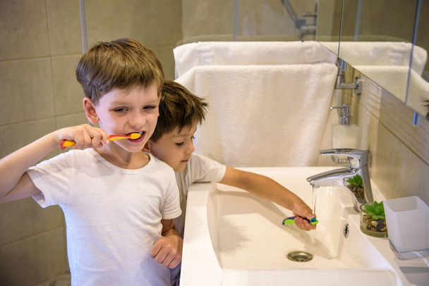 Два брати чистять зуби у ванній кімнаті. Початок нового дня
. - Фото, зображення
