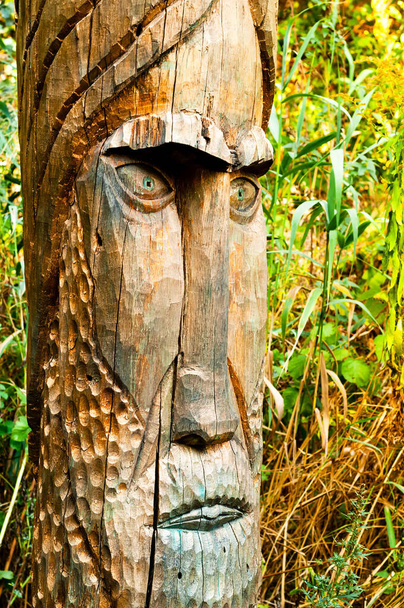 Antiguo ídolo de madera del dios eslavo tallado en un pilar de madera. El concepto de ritos paganos religiosos. - Foto, Imagen