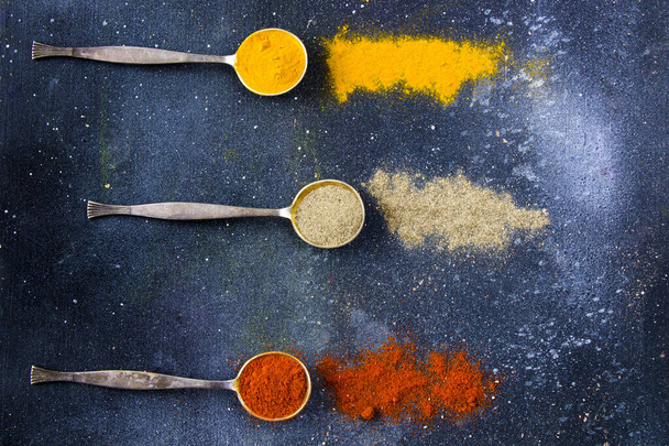 variation of spices on the vintage silver spoons, all spices on the table, colorful food background - Foto, immagini