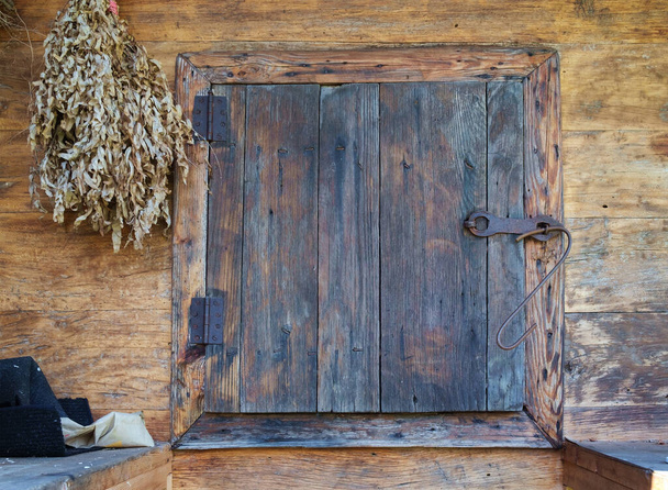 Eine quadratische Tür in der alten Holzlagerhüttenfassade - Foto, Bild