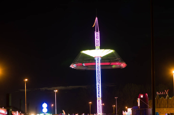 Točící se kolotoč rozmazaný pohybem v zábavním parku v noci v Arnhemu, Nizozemsko - Fotografie, Obrázek
