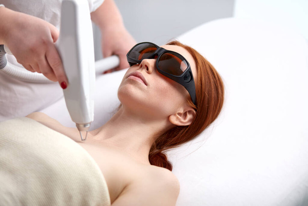 skin and body care. woman receives an electric massage in beauty salon - Zdjęcie, obraz