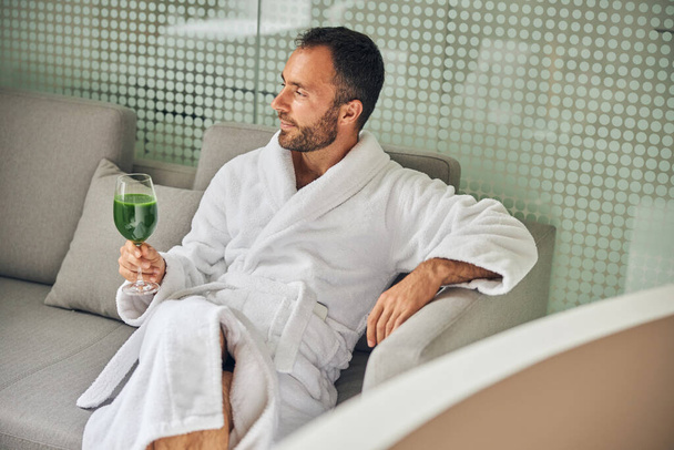 Przystojny młodzieniec pijący koktajl w salonie spa - Zdjęcie, obraz