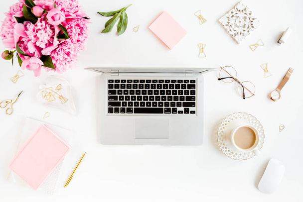 Flat lay womens office desk. Female workspace with laptop, pink peonies bouquet, accessories on white background. Top view feminine background. - 写真・画像